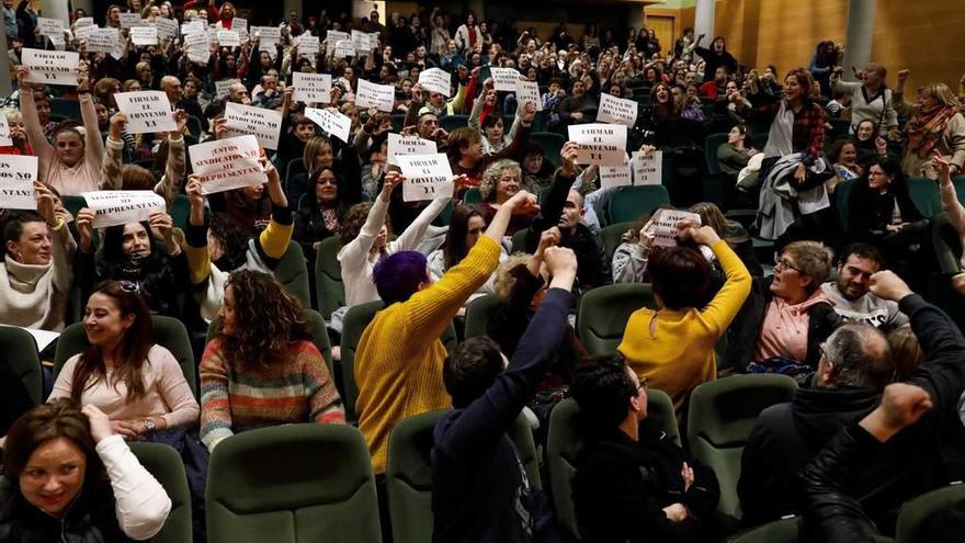 Un grupo de trabajadores muestra carteles exigiendo la firma del convenio y contra los sindicatos, mientras que otros les responden con el puño en alto ayer en Gijón.