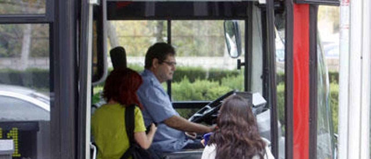 Dos jóvenes suben a un autobús de la EMT.