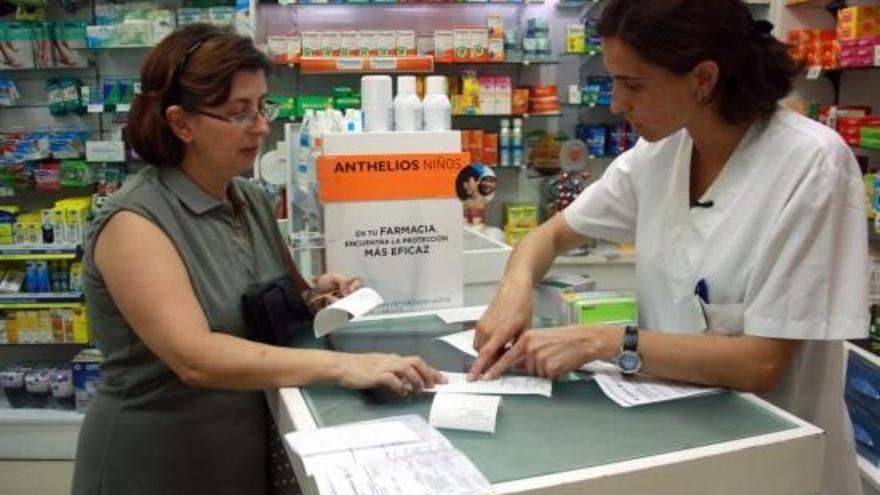 Una farmacèutica atén una usuària