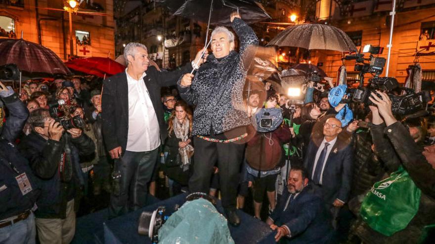Trinidad Sánchez dirigiendo el Himno mientras la intentaban cubrir con un paraguas.