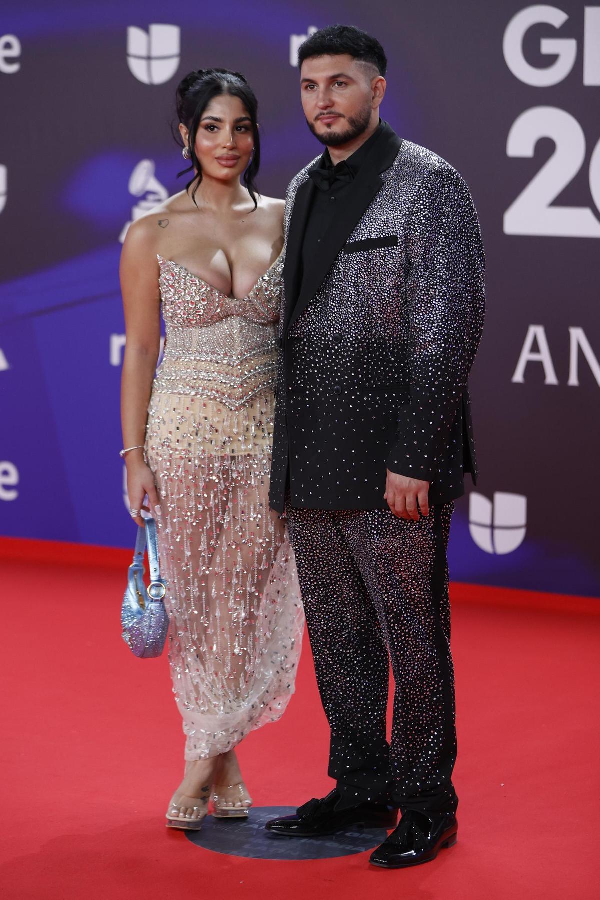 - El cantante español Omar Montes (d) y Lola Romero posan para los fotógrafos en la alfombra roja de la gala anual de los Latin Grammy, este jueves en Sevilla.