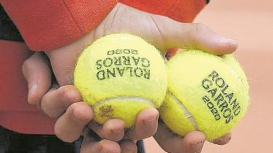 Un recogepelotas, con dos de las bolas de esta edición.