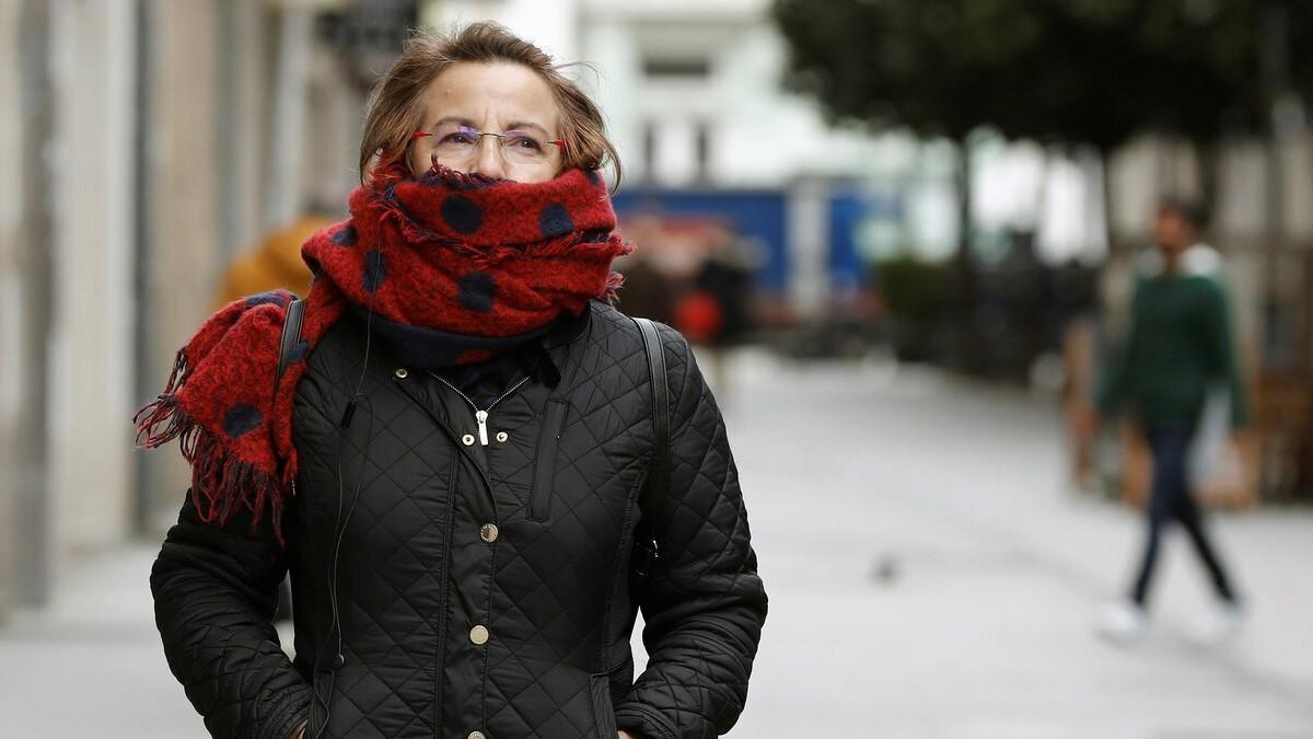 Una mujer camina bien abrigada por Lugo