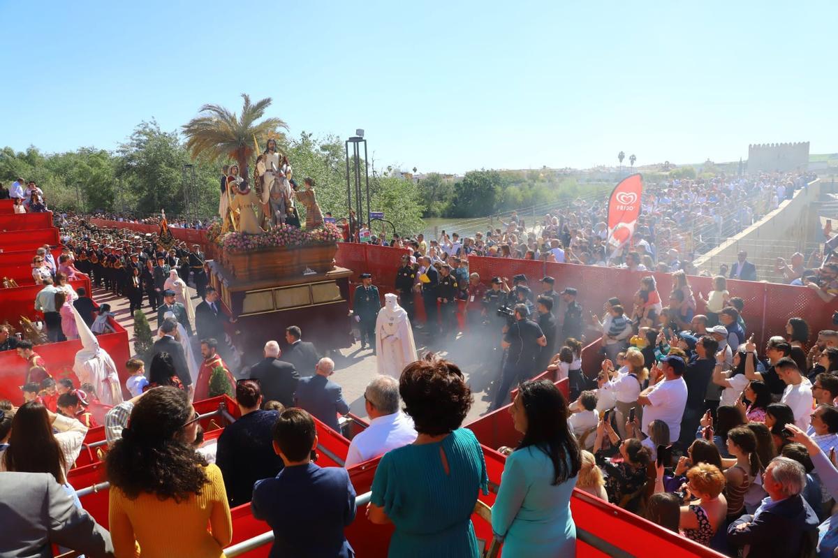 La Borriquita en su entrada a la carrera oficial de la Semana Santa de Córdoba, ante la expectación de miles de personas en el Puente Romano y su entorno.