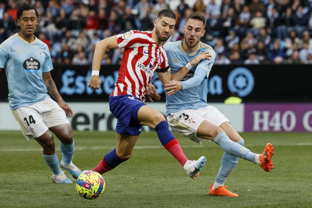 VIGO (PONTEVEDRA), 12/02/2023.-  El defensa del Celta de Vigo Óscar Mingueza (d) disputa un balón con durante el delantero belga del Atlético de Madrid Yannick Carrasco (c) durante el partido correspondiente a la Jornada 21 de LaLiga Santander que enfrenta a ambos equipos este domingo en el Estadio de Abanca Balaídos de Vigo (Galicia). EFE/ Lavandeira