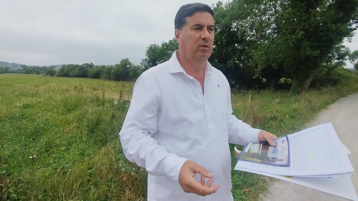 el portavoz municipal del PP de Llanera, Silverio Argüelles, con la finca del yacimiento detrás.