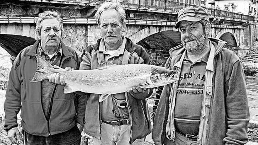 Javier, Federico y Nayo Vega Díaz, de la saga de «La Pina», con el salmón que el segundo sacó en el Sella.