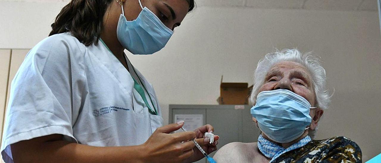 Una enfermera, ayer, vacunando con la tercera dosis a una residente de Campolongo.