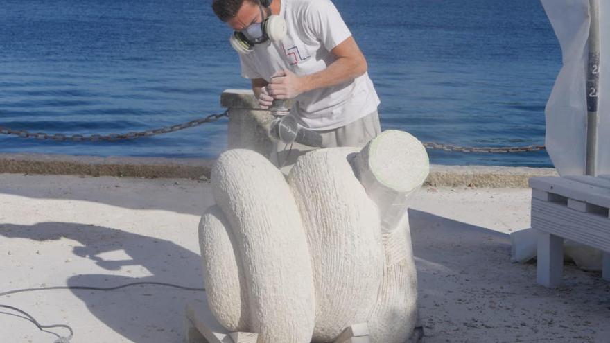 Uno de los artistas trabaja en su escultura. // Muñiz