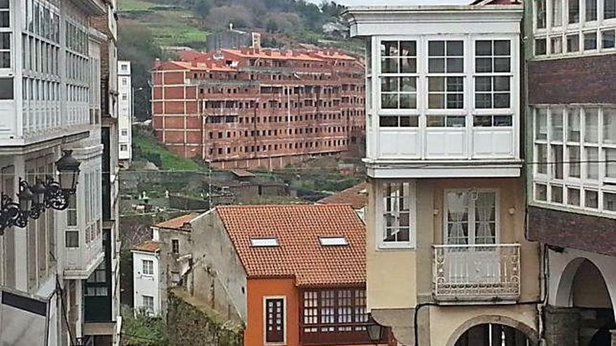 El edificio Mandeo 50, al fondo, y, en primer término, varias viviendas del casco histórico.