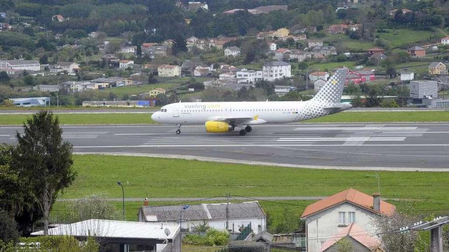 Un avión de Vueling, en la pista de Alvedro rodeado de viviendas.