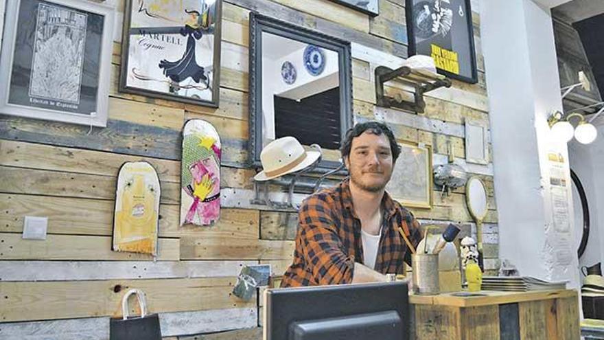 Pau Guitelzon, propietario de Robin Wood, posa en el mostrador de la tienda, donde se pueden observar varios de sus artículos a su espalda