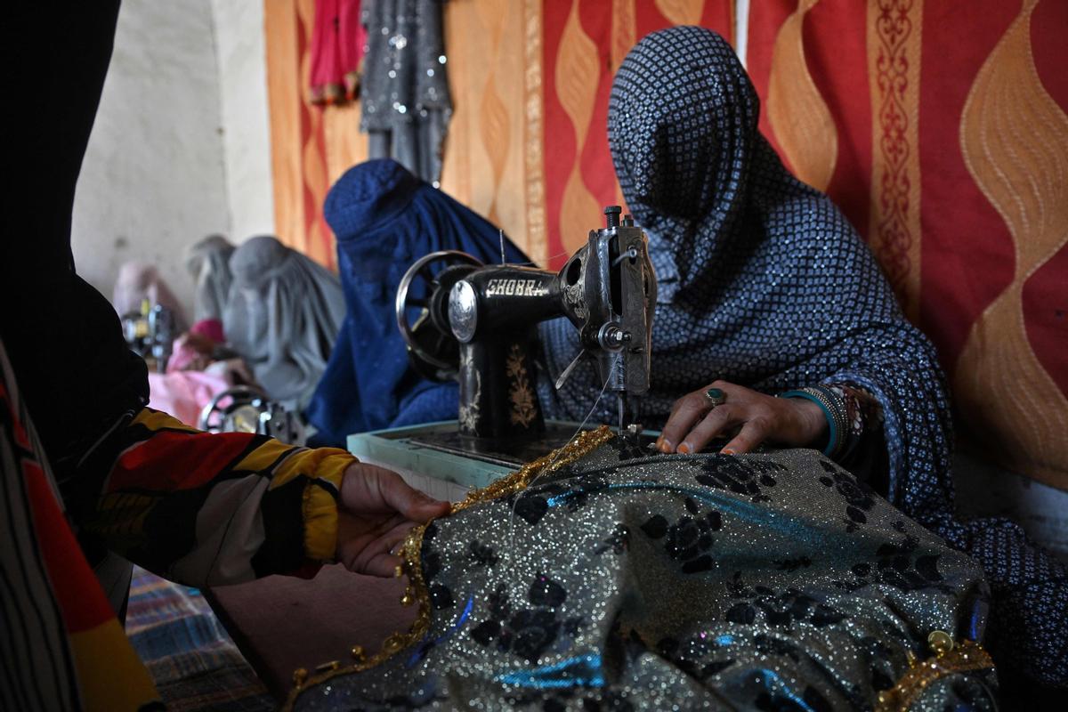 Afganas con burka trabajando en una fábrica de jabón y ropa en Kandahar