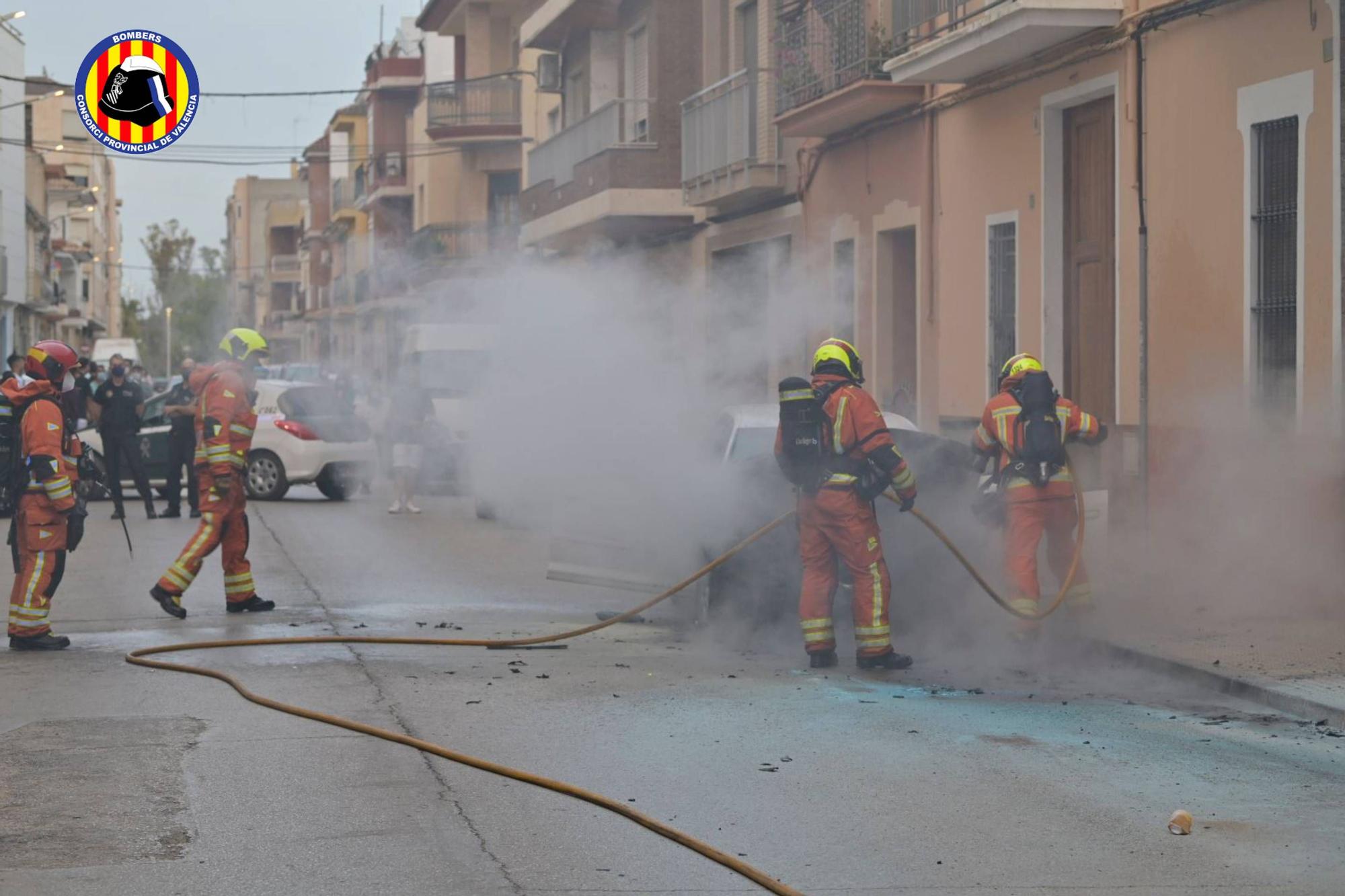 Los bomberos apagan un vehículo incendiado en plena calle en Carlet