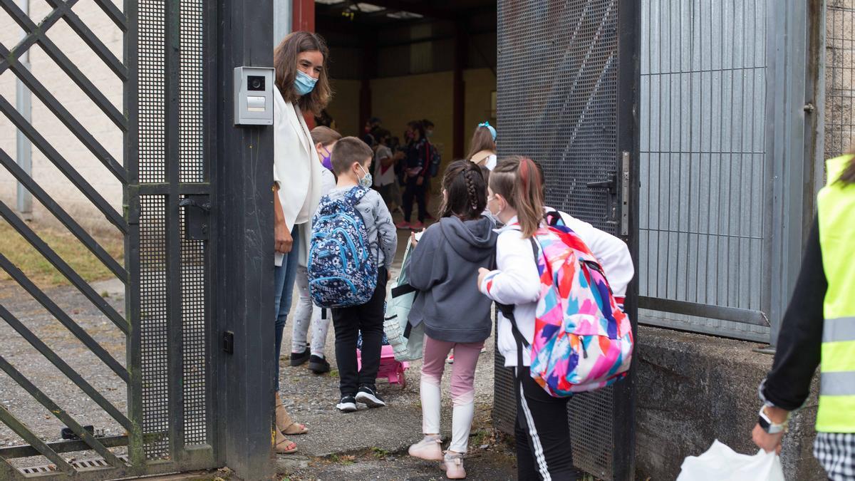 Un grupo de niños entran a su colegio.