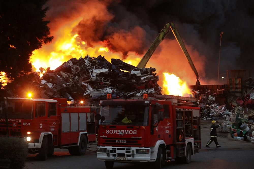 Labores de extinción del incendio de un desguace en Gijón