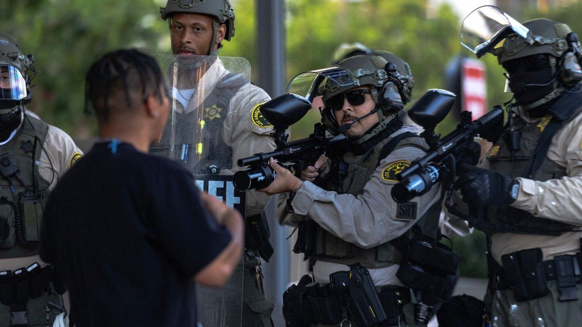 Agentes de policía apuntan con sus armas a un manifestante en Los Ángeles.