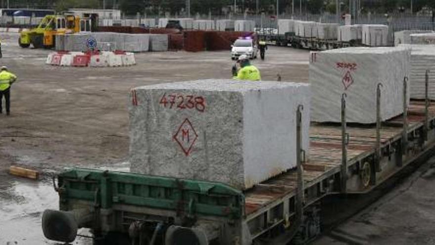 El tren, compuesto por 13 vagones cargados con pesados bloques de granito, accedió a los muelles a mediodía.  // R. Grobas