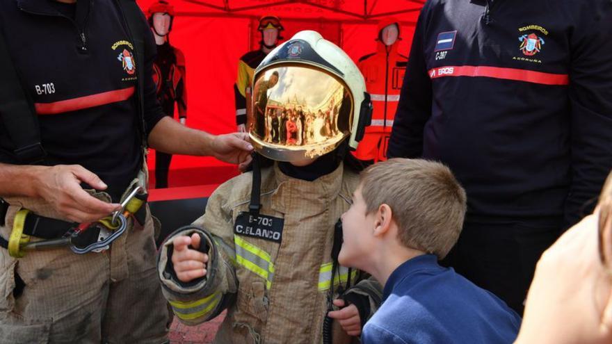 Un niño prueba un equipo de bomberos este jueves. | | C. PARDELLAS