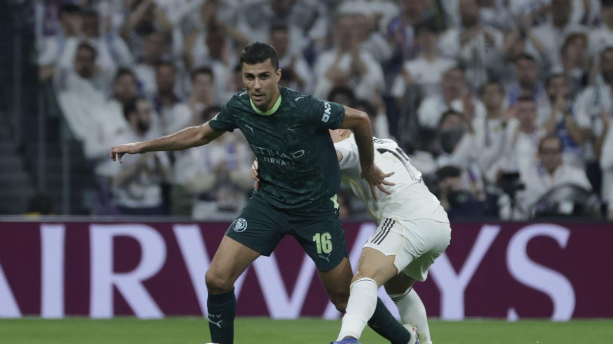 El centrocampista español del Manchester City, Rodri (i), se lleva el balón ante el delantero turco del Real Madrid, Arda Guler, durante el encuentro correspondiente a la ida de los octavos de final de la Liga de Campeones que Real Madrid y Manchester City del año pasado.