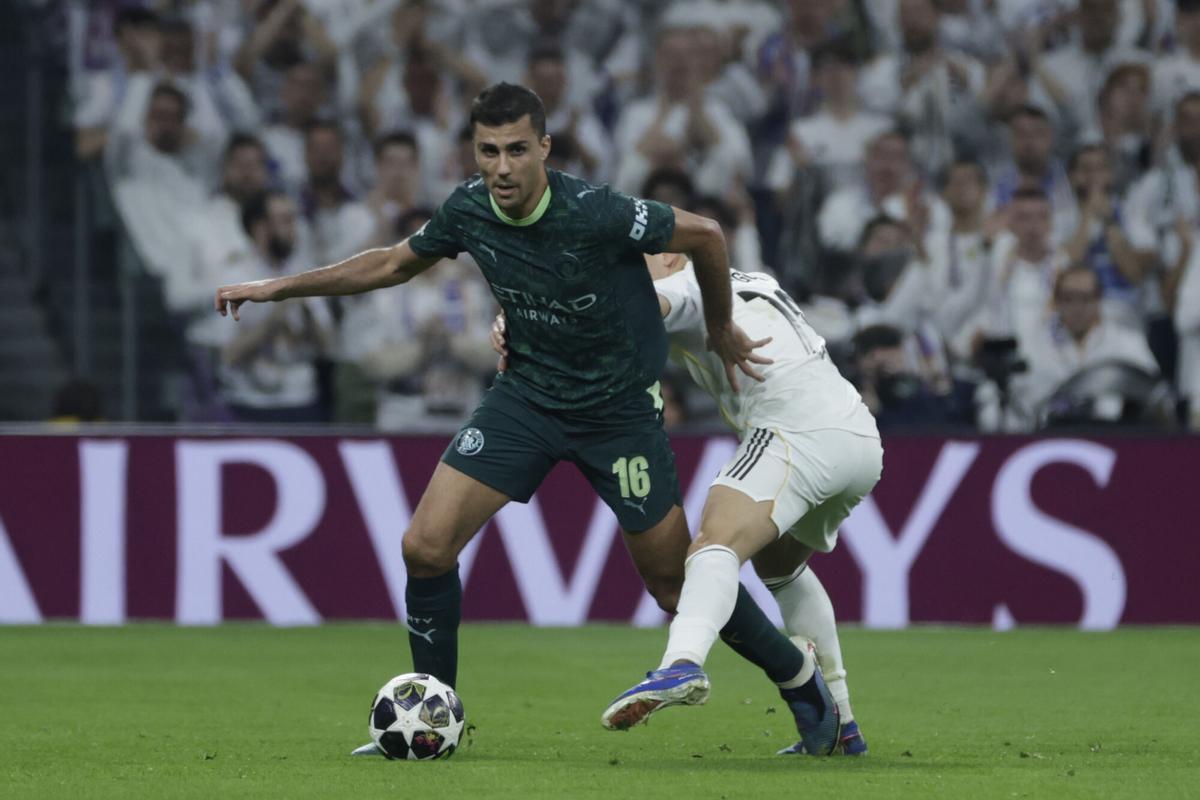 El centrocampista español del Manchester City, Rodri (i), se lleva el balón ante el delantero turco del Real Madrid, Arda Guler, durante el encuentro correspondiente a la ida de los octavos de final de la Liga de Campeones que Real Madrid y Manchester City del año pasado.