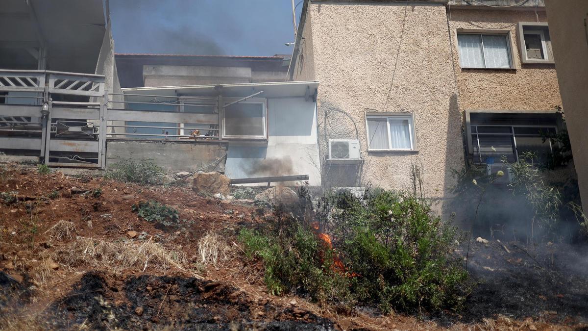 Fuego junto a unas viviendas de Kiryat Shmona, en Israel, tras el impactod e un proyectil lanzado por Hamás.