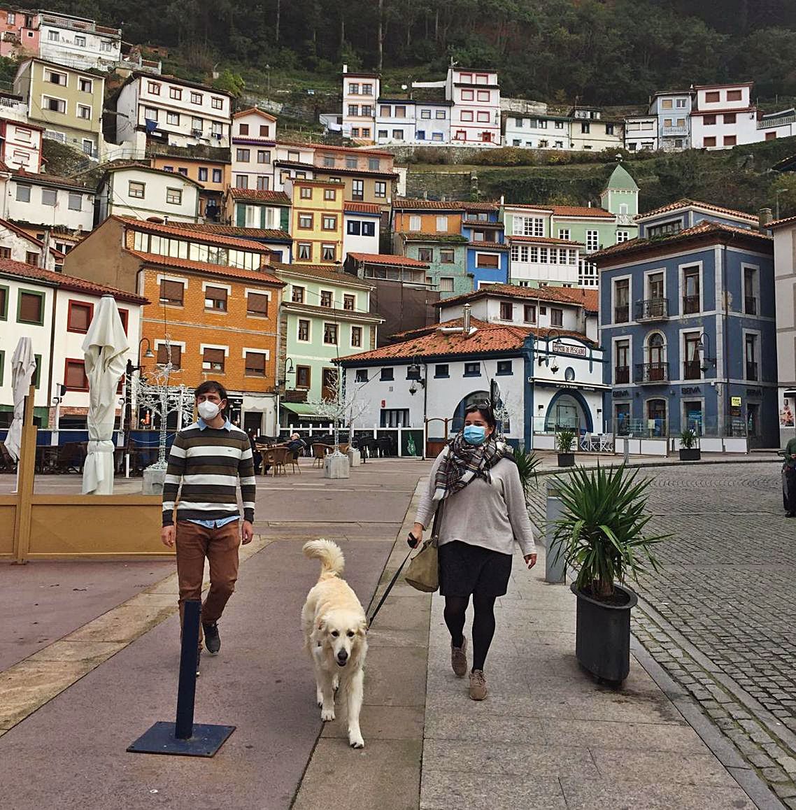 Paula Gay e Iván Campos, con su perro, este domingo, en Cudillero; al fondo, el anfiteatro.