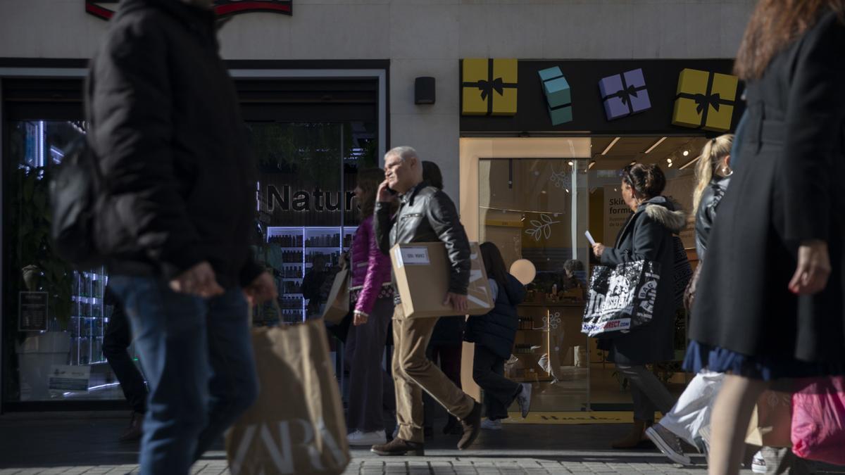 Varias personas con bolsas de la compra en las rebajas de invierno de este año.