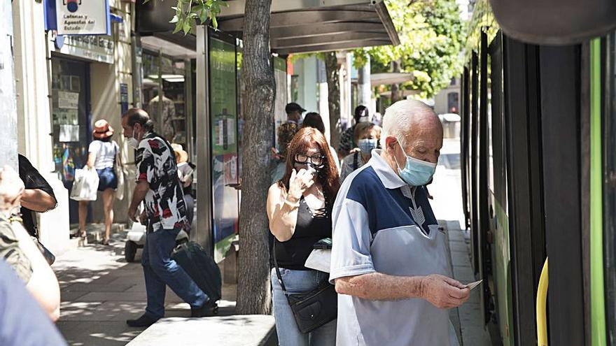 Pujant al bus amb nas i boca tapats | OSCAR BAYONA