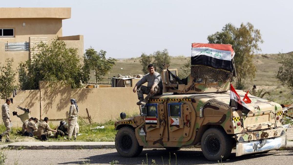 An Iraqi soldier sits on a military vehicle at Udhaim dam