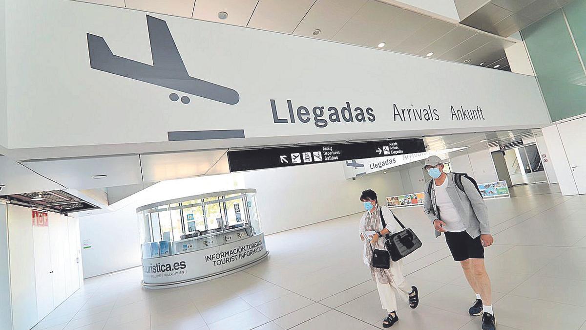 Dos turistas llegan al aeropuerto de Corvera.