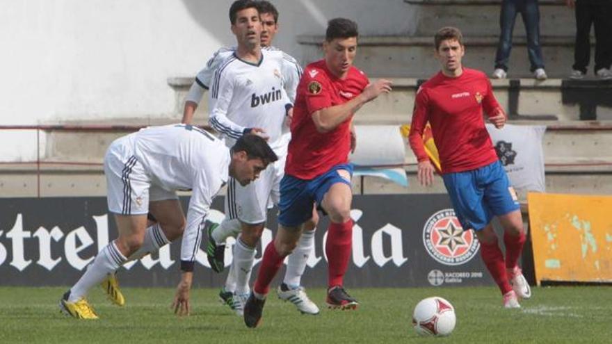 El delantero del Ourense Borja Valle inicia una contra vigilado por jugadores del Real Madrid C, ayer, en O Couto. // Jesús Regal