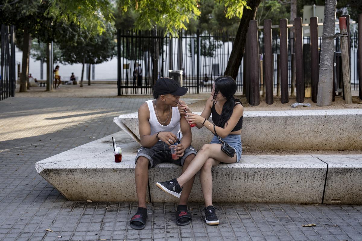 Una pareja toma un refrigerio para pailar el sofoco en plena ola de calor en el Parc dels Ocells de L'Hospitalet.