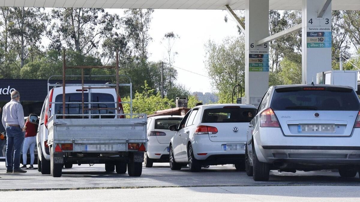 Varios conductores en una estación de servicio de Santiago repostan gasolina estos días