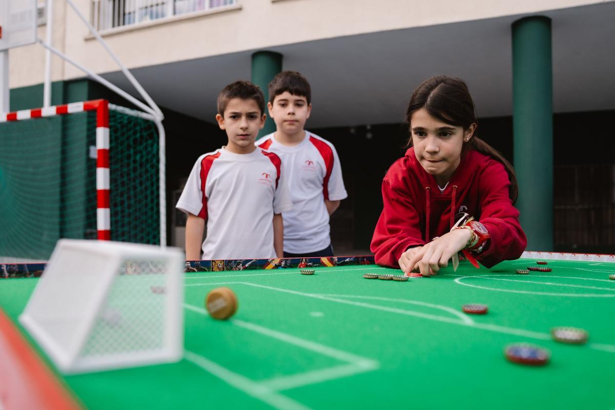 Niños juegan al fútbol chapa en el Colegio Claret de Madrid.