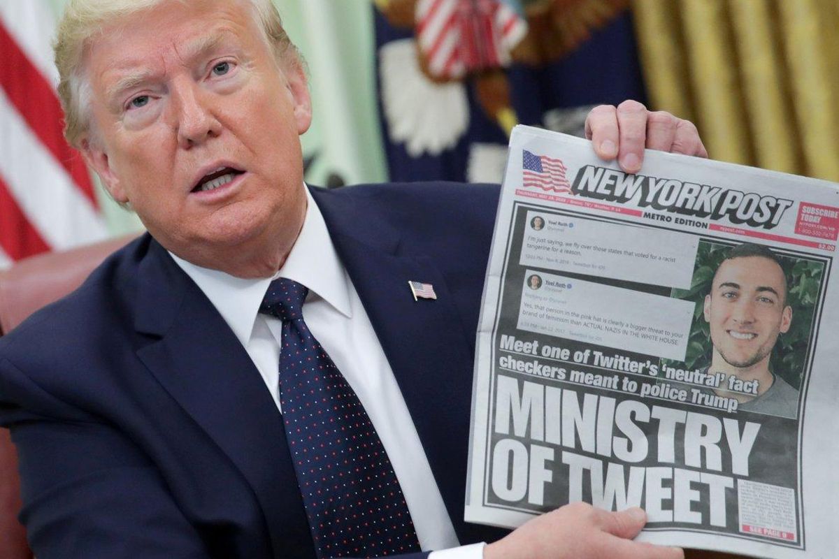 FILE PHOTO: U.S. President Donald Trump holds up a front page of the New York Post as he speaks to reporters while discussing an executive order on social media companies in the Oval Office of the White House in Washington, U.S., May 28, 2020. REUTERS/Jonathan Ernst/File Photo