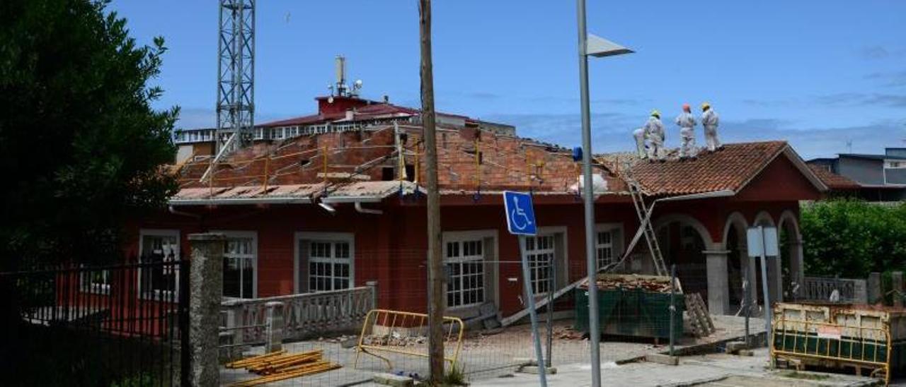 Obreros con los trajes especiales en el tejado de la biblioteca Torrente Ballester. | // GONZALO NÚÑEZ