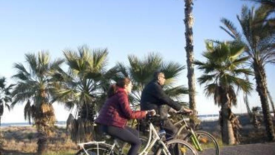 Dos ciclistas ruedan por el parque Litoral.