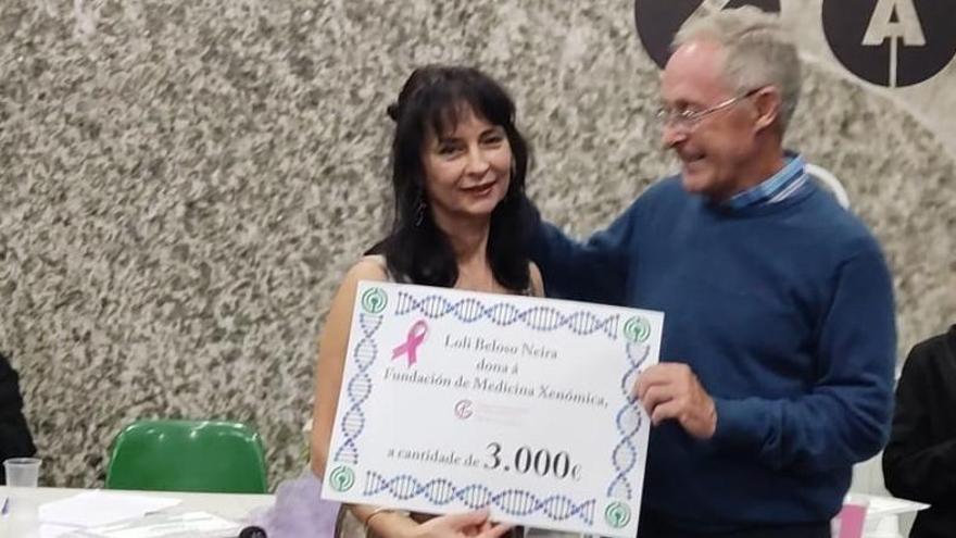 Loli Beloso entrega el cheque a Ángel Carracedo.