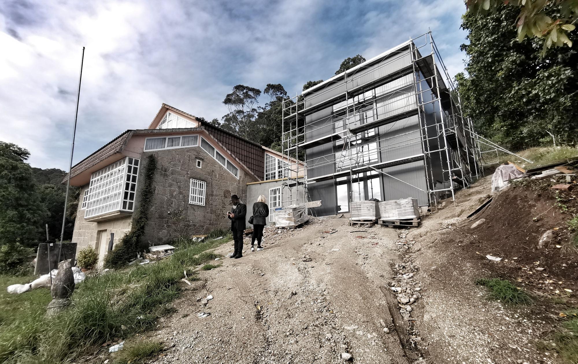 Contraste de la piedra de la antigua casa y el aluminio de la nueva nave.