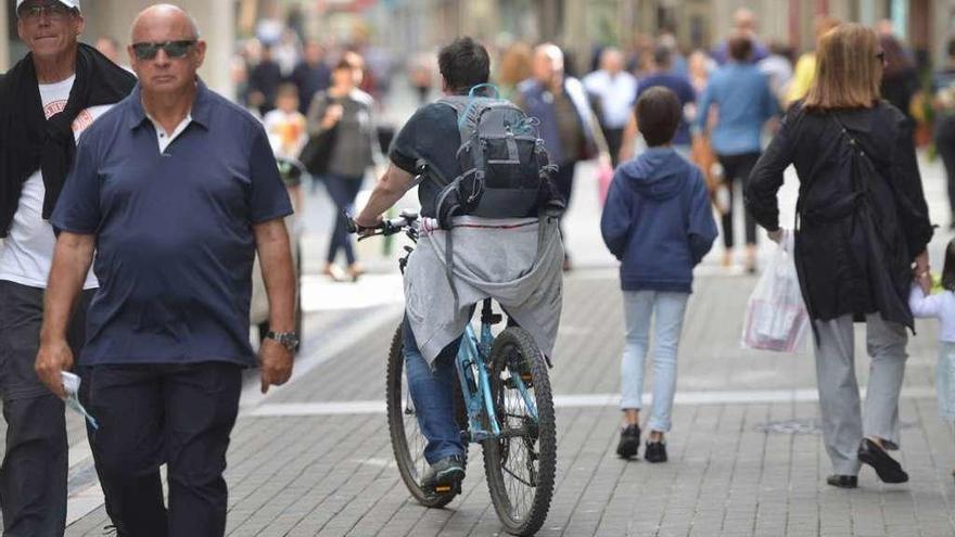Un ciclista circula entre los peatones ayer en la calle Michelena. // G. S.