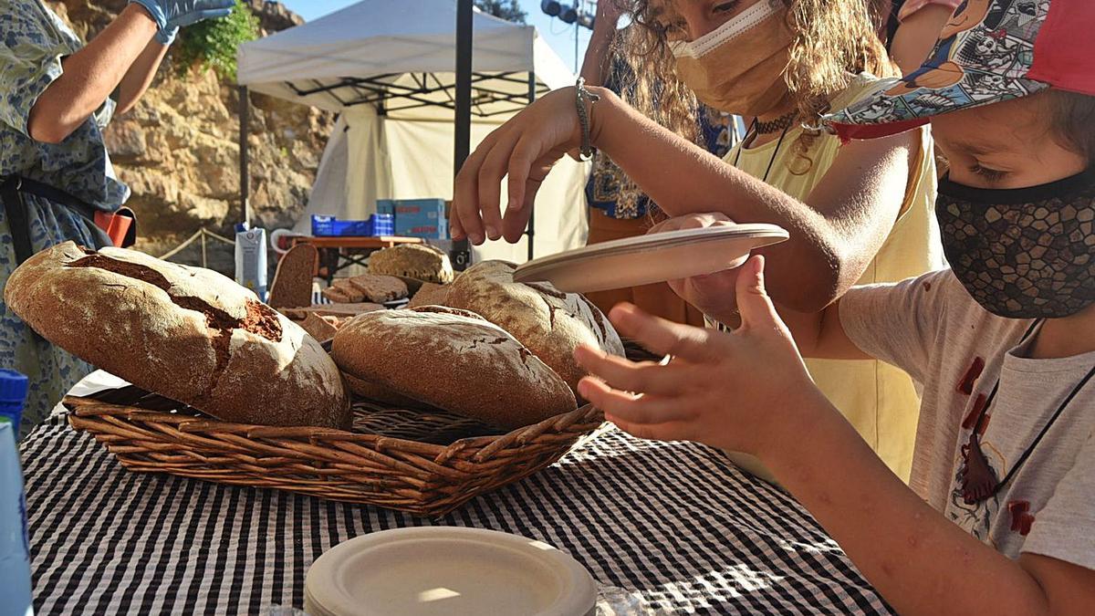 Dos niños, en el puesto de la panadería Es Brot antes de que comience la conferencia.  