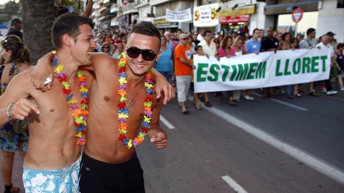 Dos jóvenes turistas, junto a la manifestación de este lunes en Lloret.