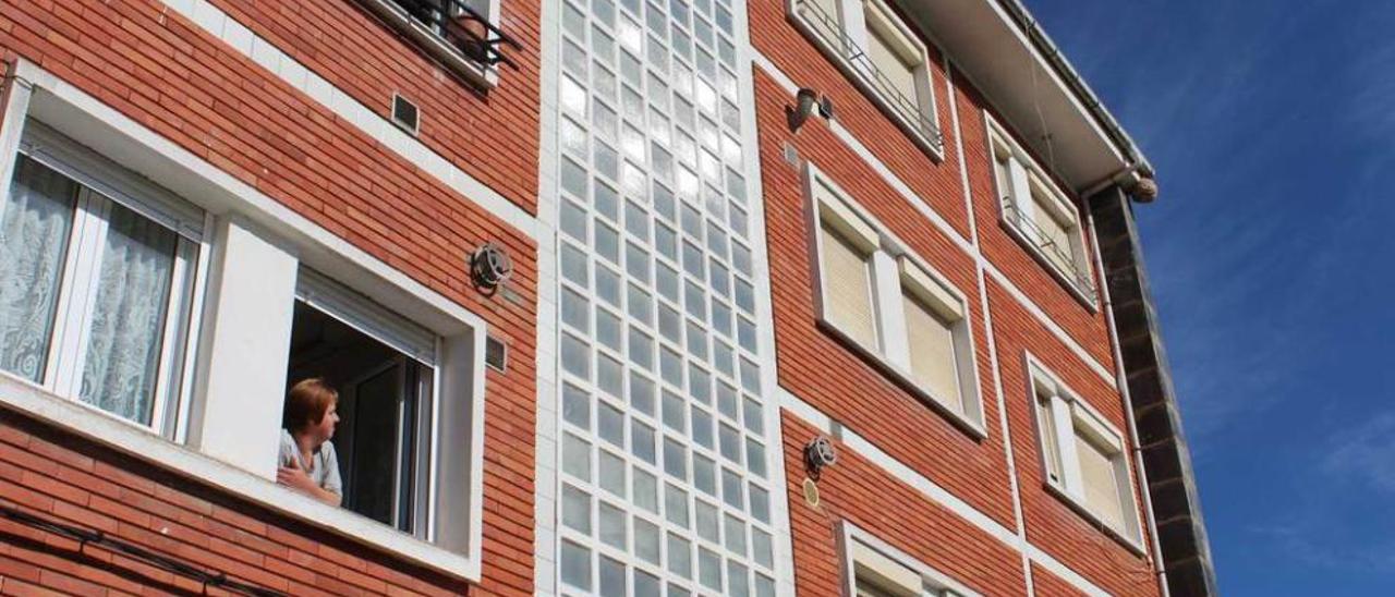 Isabel Vázquez observa desde su ventana el nido situado en el alero del edificio.