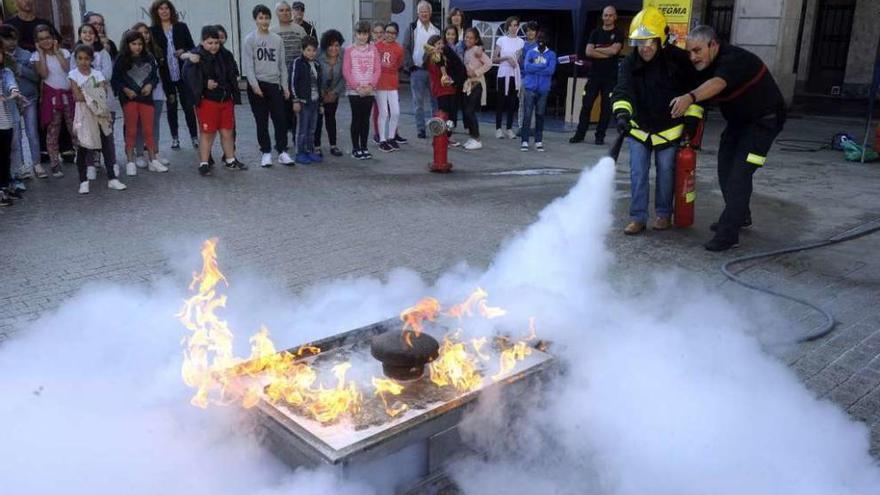 Demostración ante escolares de cómo se sofoca un incendio, ayer en la plaza de María Pita.