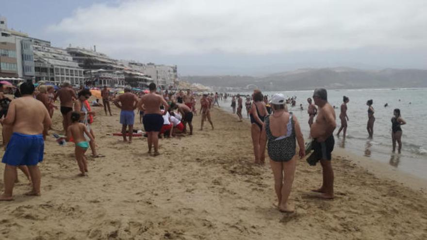 Sanitarios atienden al hombre de 83 años que falleció ayer en la playa de Las Canteras, tras sufrir una parada cardiorrespiratoria.