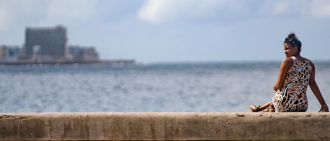 Una mujer descansa en el malecón de La Habana (Cuba).