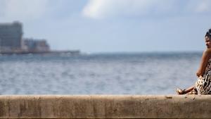 Una mujer descansa en el malecón de La Habana (Cuba).