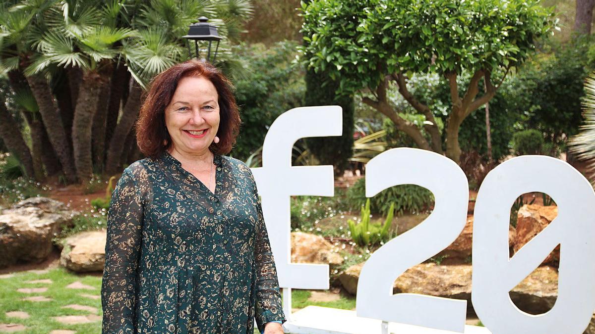 Rosa Castells, directora y creadora de Formentera20, posando junto al logotipo del evento. 