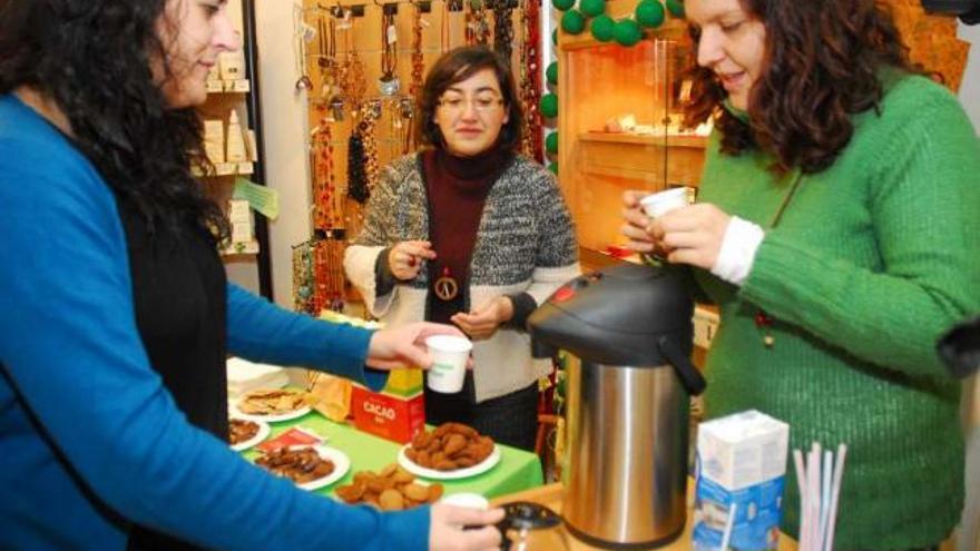 Varias personas degustan productos de la tienda de comercio justo de Intermón en A Coruña. / noelia prada